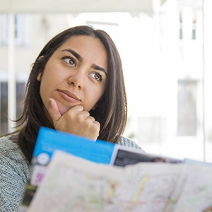 imagem de uma jovem mulher com um mapa na mão tomando decisão a respeito