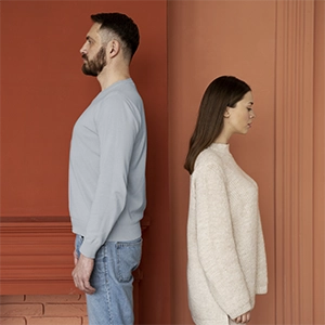 um casal com homem e mulher, de costas um para o outro, sinalizando problemas na relação