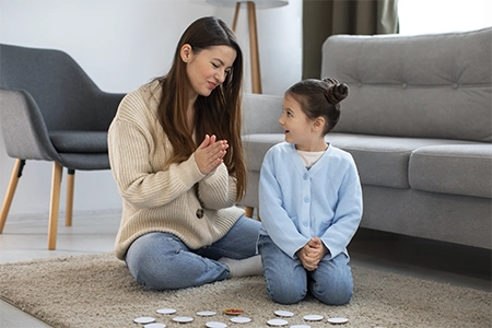 criança em terapia com jovem psicóloga