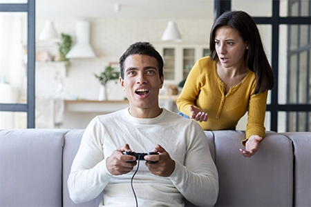 homem ignorando mulher jogando video game